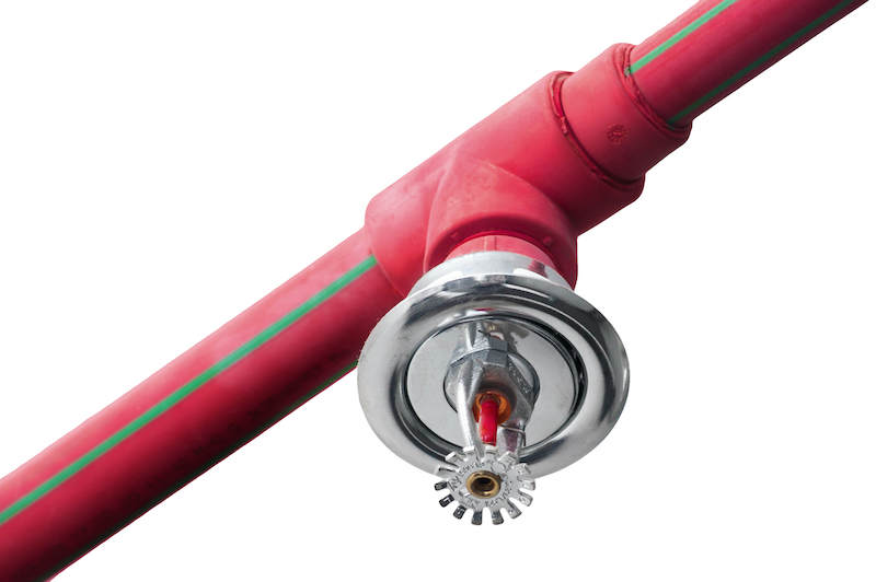 Fire sprinkler and red pipe on white ceiling background
