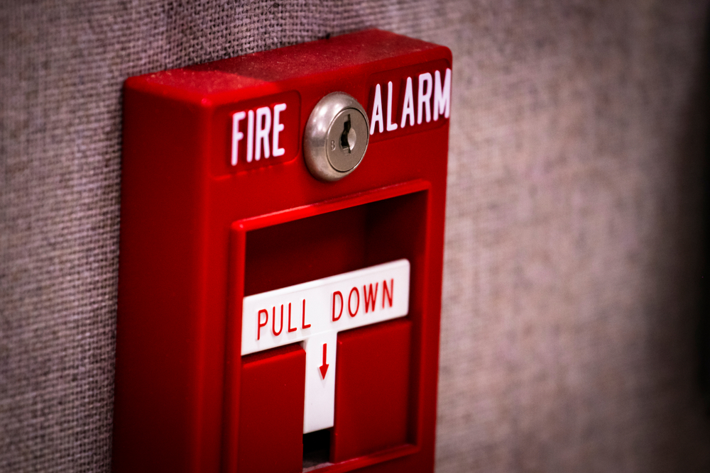 close up of manual fire alarm activation pull station on wall