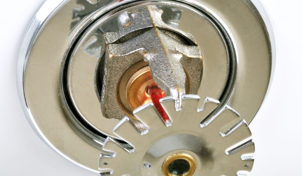 Close up of fire sprinkler head on ceiling of building