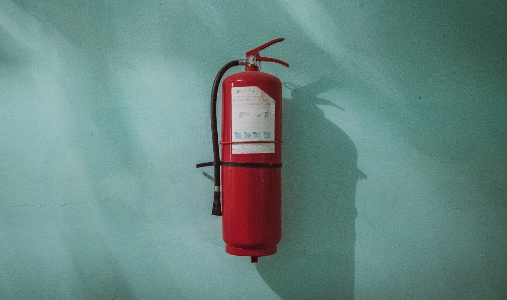 Fire extinguisher mounted on a green wall