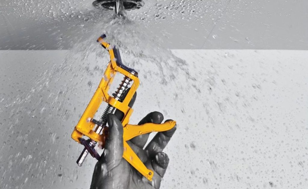 Man shutting of fire sprinkler with Shutgun tool